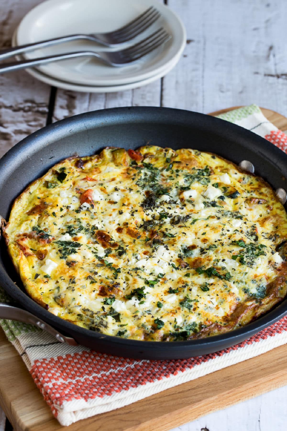 Greek Frittata shown in frittata pa on napkin and cutting board