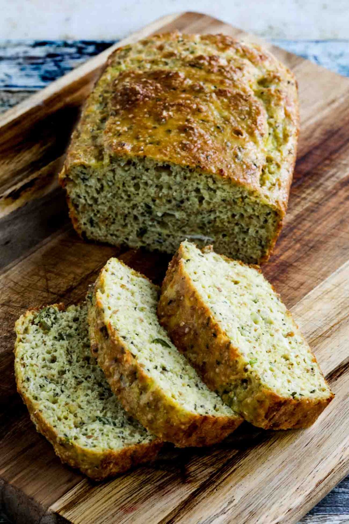 Savory Almond Flour Bread shown on cutting board with three slices cut