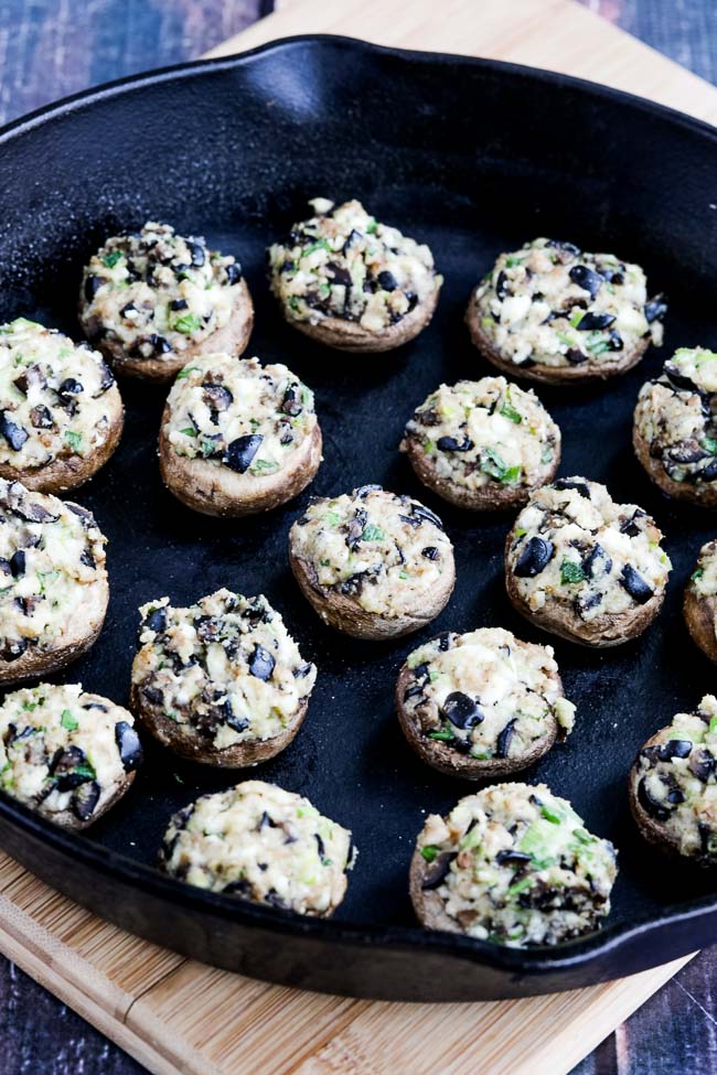 Keto Stuffed Mushrooms with Olives and Feta shown in cast-iron pan.